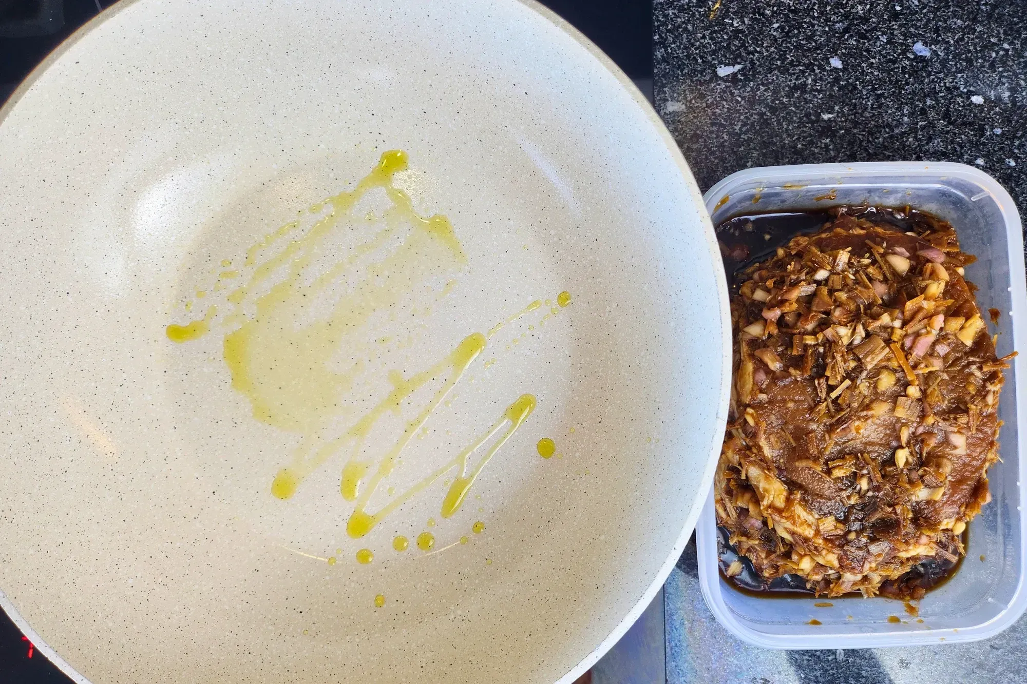 A pan with oil with a box of marinated pork chops