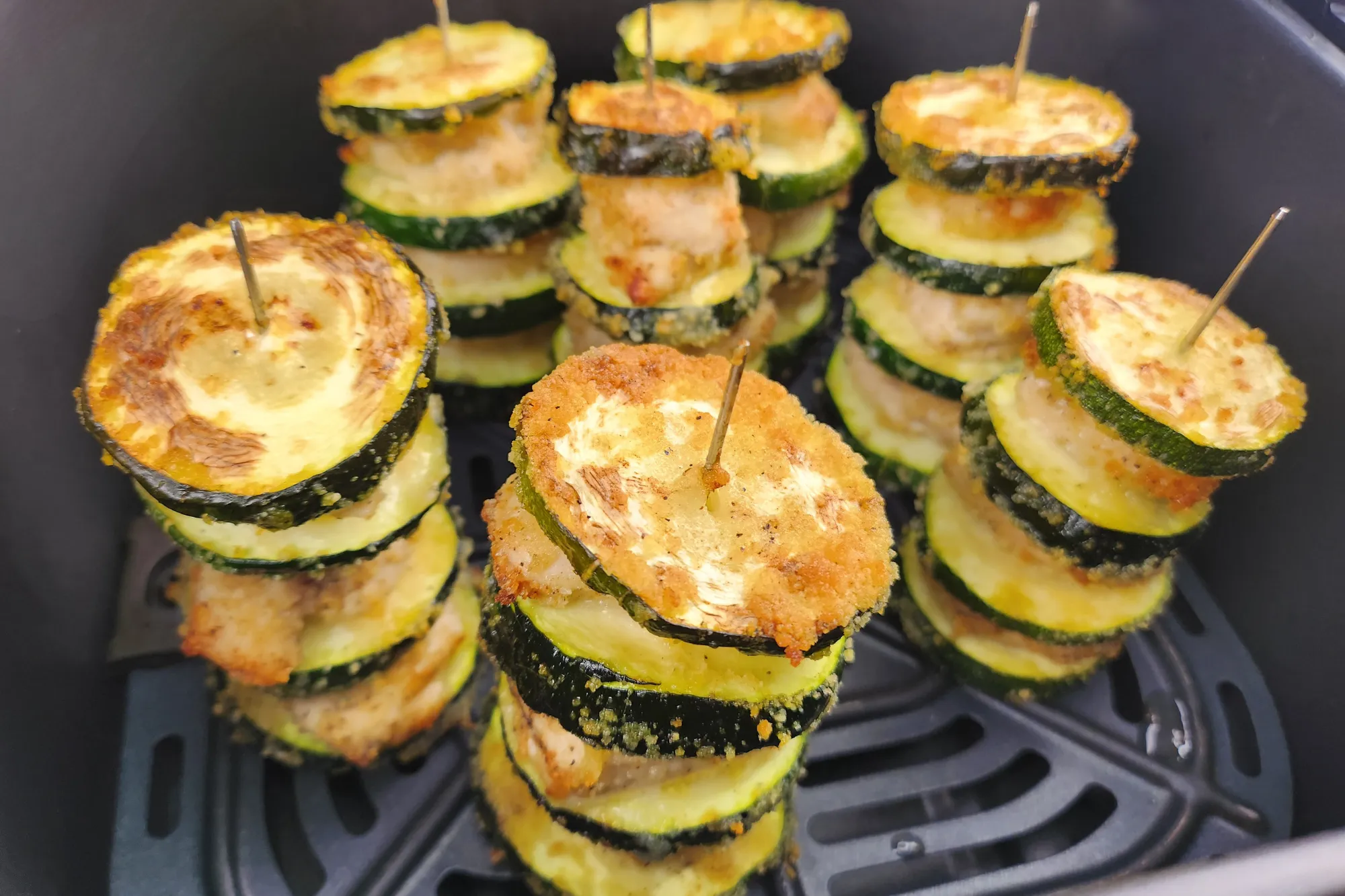 A side of cooked Chicken and Zucchini Skewers in an air fryer basket.