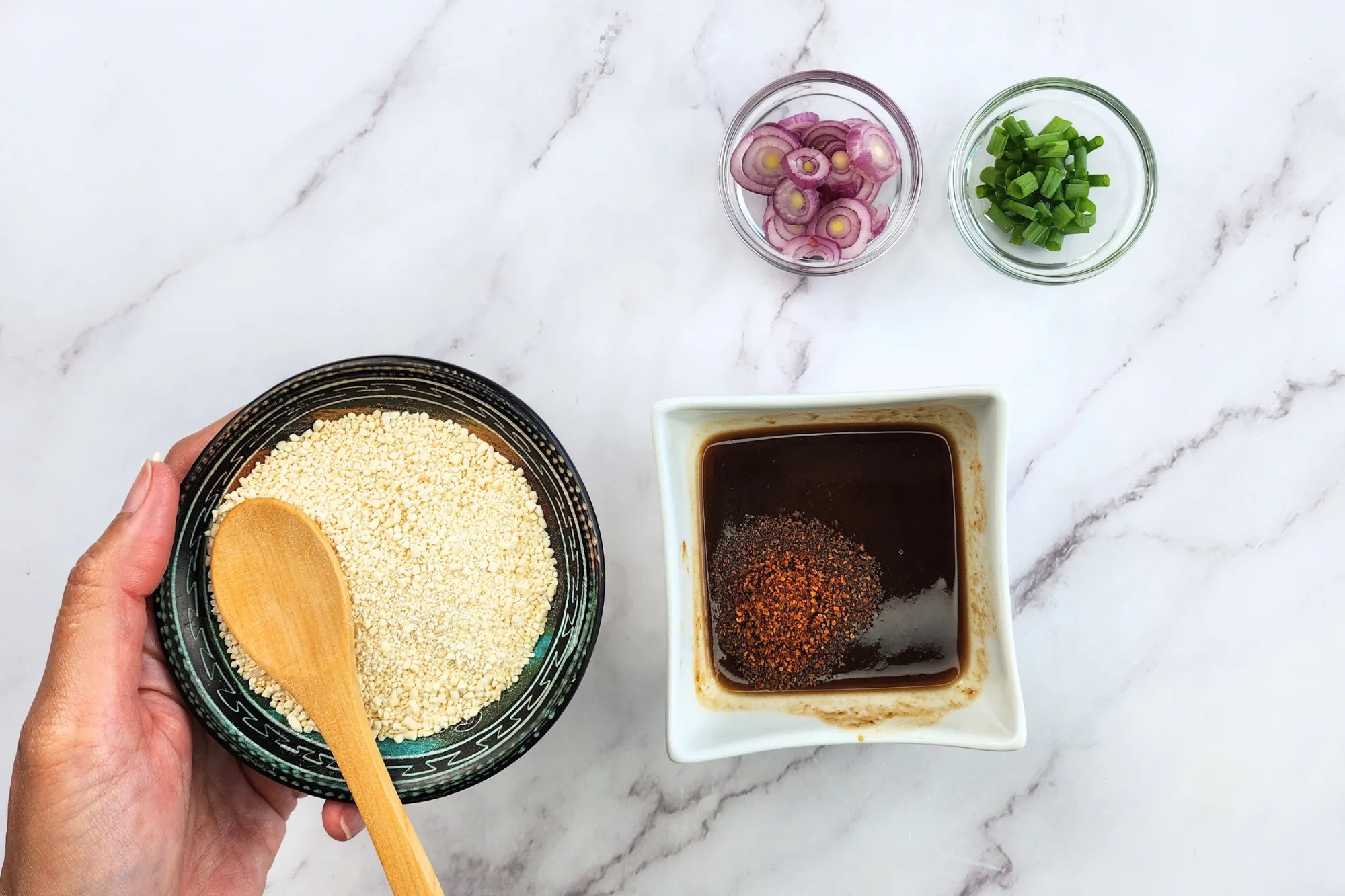 Add chili flakes, toasted rice powder, shallots, and green onions