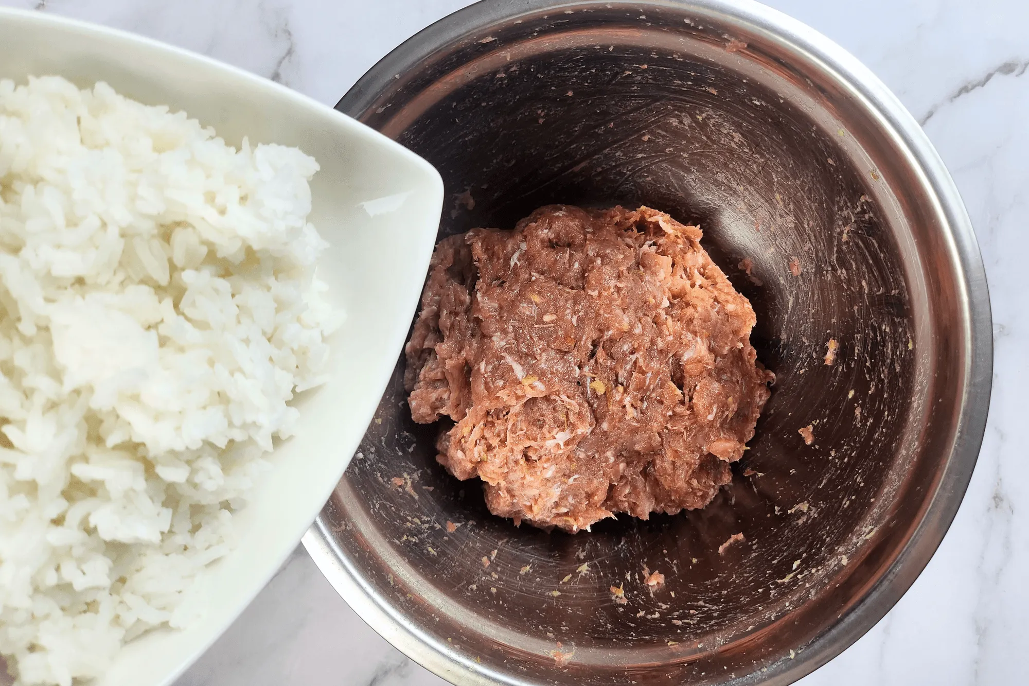 Add cooked rice and glass noodles to the mixture and knead until well incorporated. Take a small portion of the mixture and cook it in the microwave. Taste and adjust the seasoning if necessary before stuffing into the sausage casing.