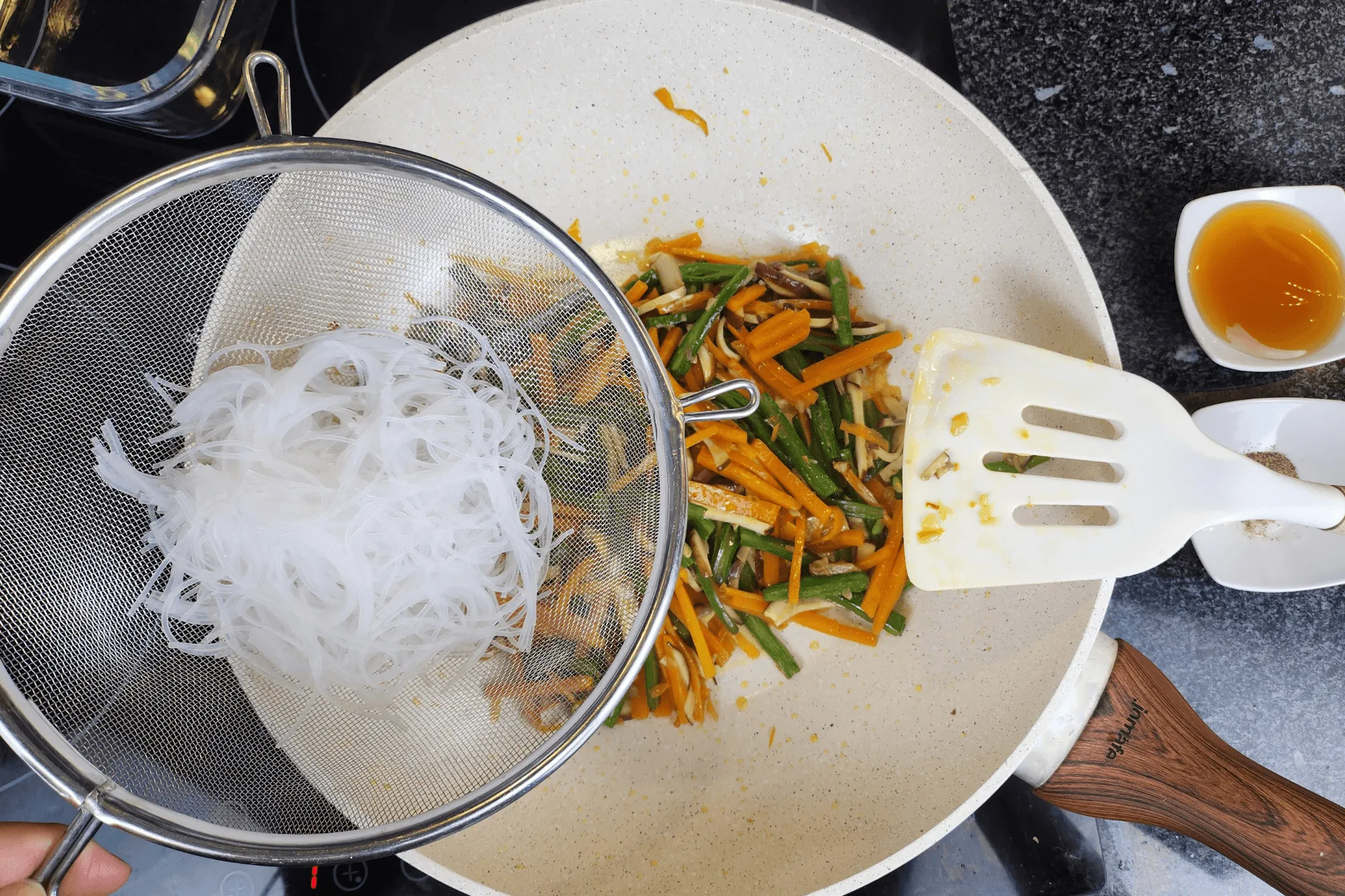 Add the glass noodles and season with vegetarian oyster sauce and a pinch of white pepper. Stir until everything is evenly mixed. Remove from heat and let cool.