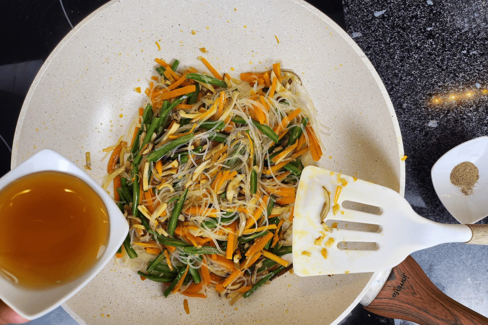 Add the glass noodles and season with vegetarian oyster sauce and a pinch of white pepper. Stir until everything is evenly mixed. Remove from heat and let cool.