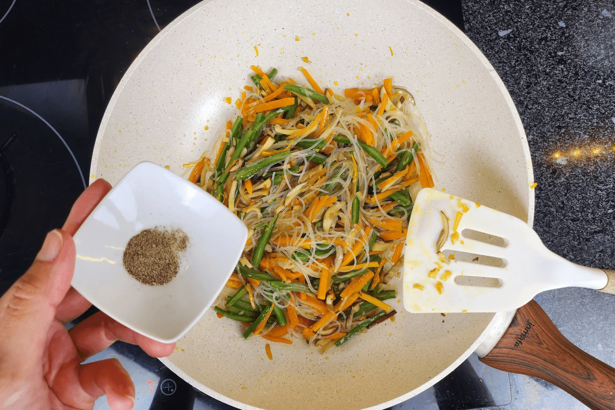 Add the glass noodles and season with vegetarian oyster sauce and a pinch of white pepper. Stir until everything is evenly mixed. Remove from heat and let cool.