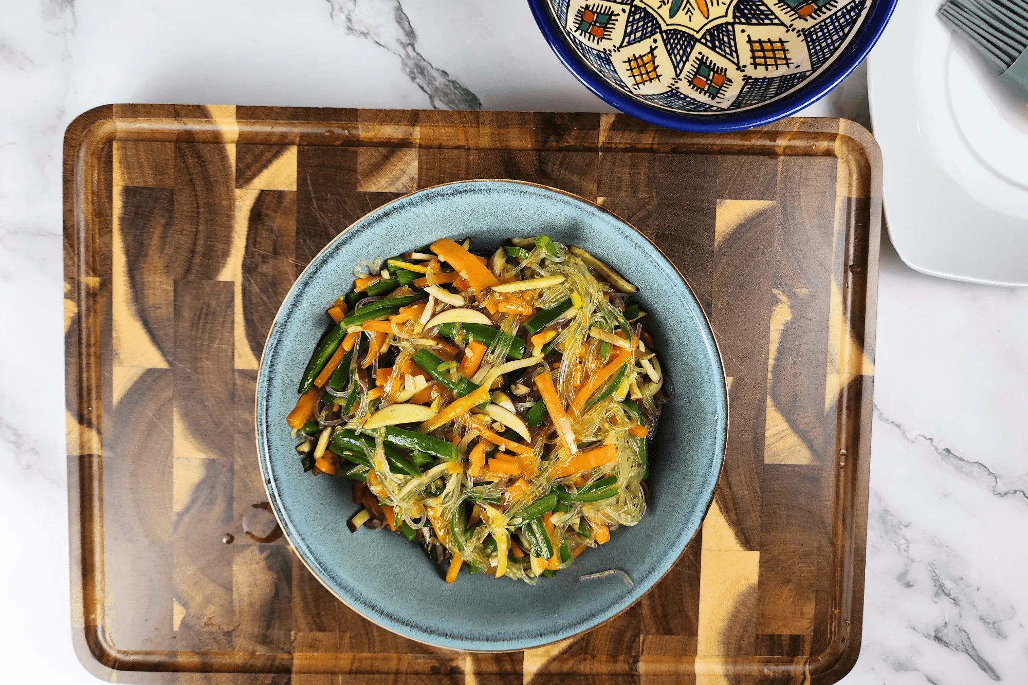 Add the glass noodles and season with vegetarian oyster sauce and a pinch of white pepper. Stir until everything is evenly mixed. Remove from heat and let cool.