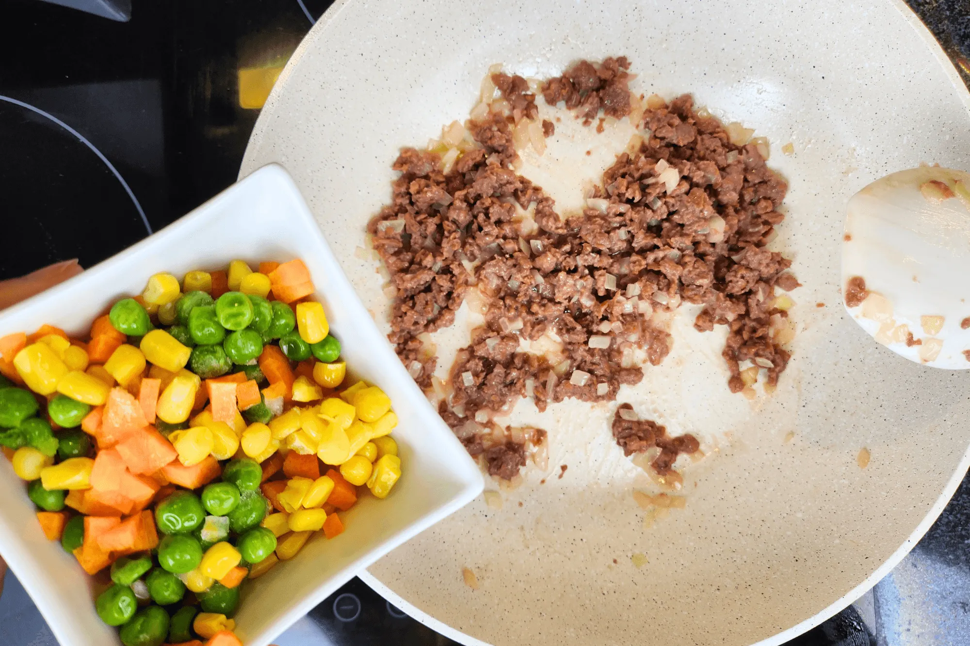 Add the mixed vegetables and continue stirring.