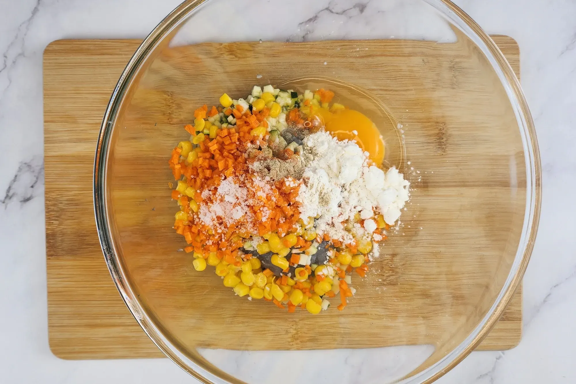 All ingredients in a mixing bowl on the top of wooden board.