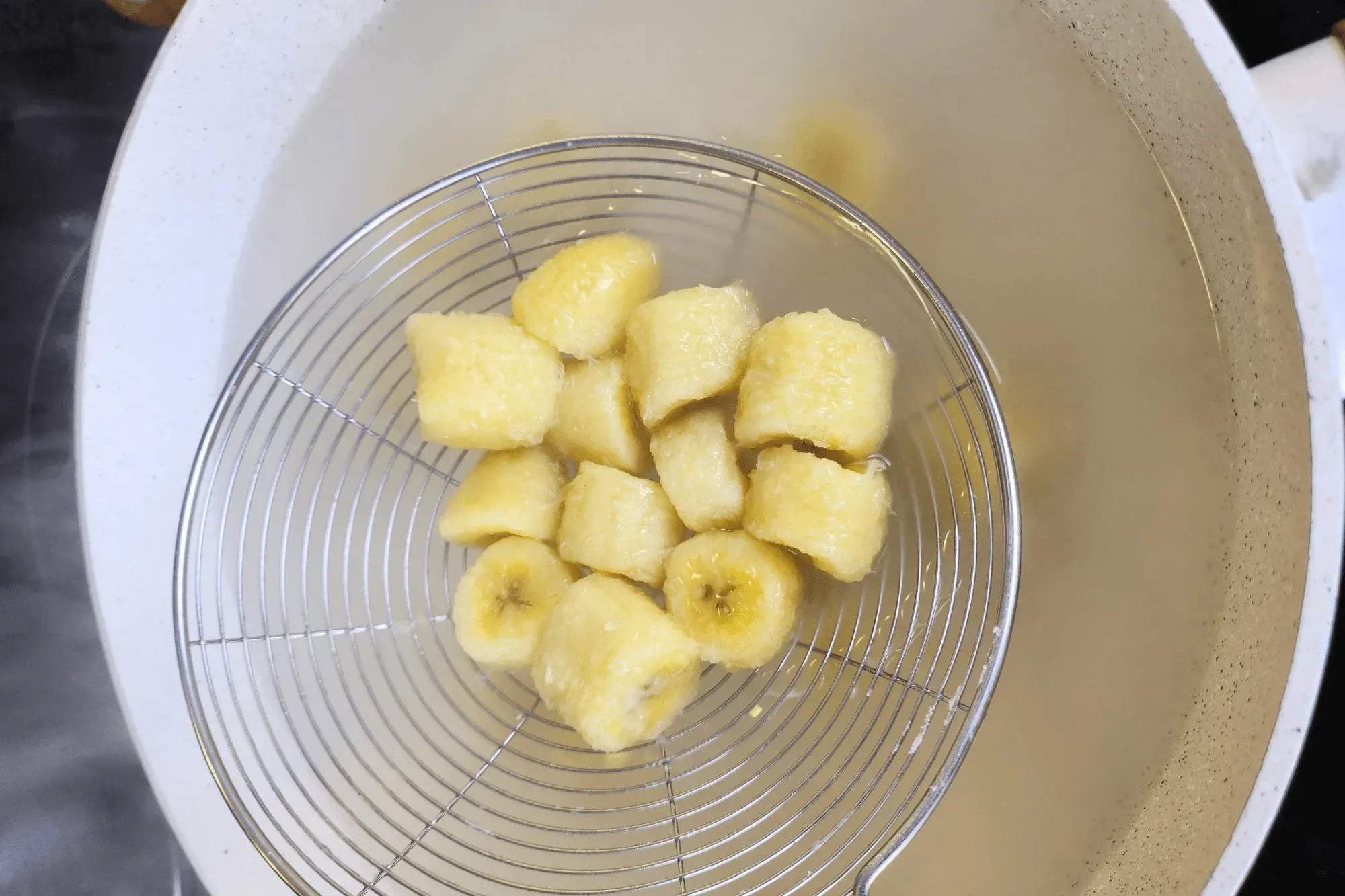 Bring a pot of water to a boil, then add the coated banana pieces. Stir gently to prevent sticking.