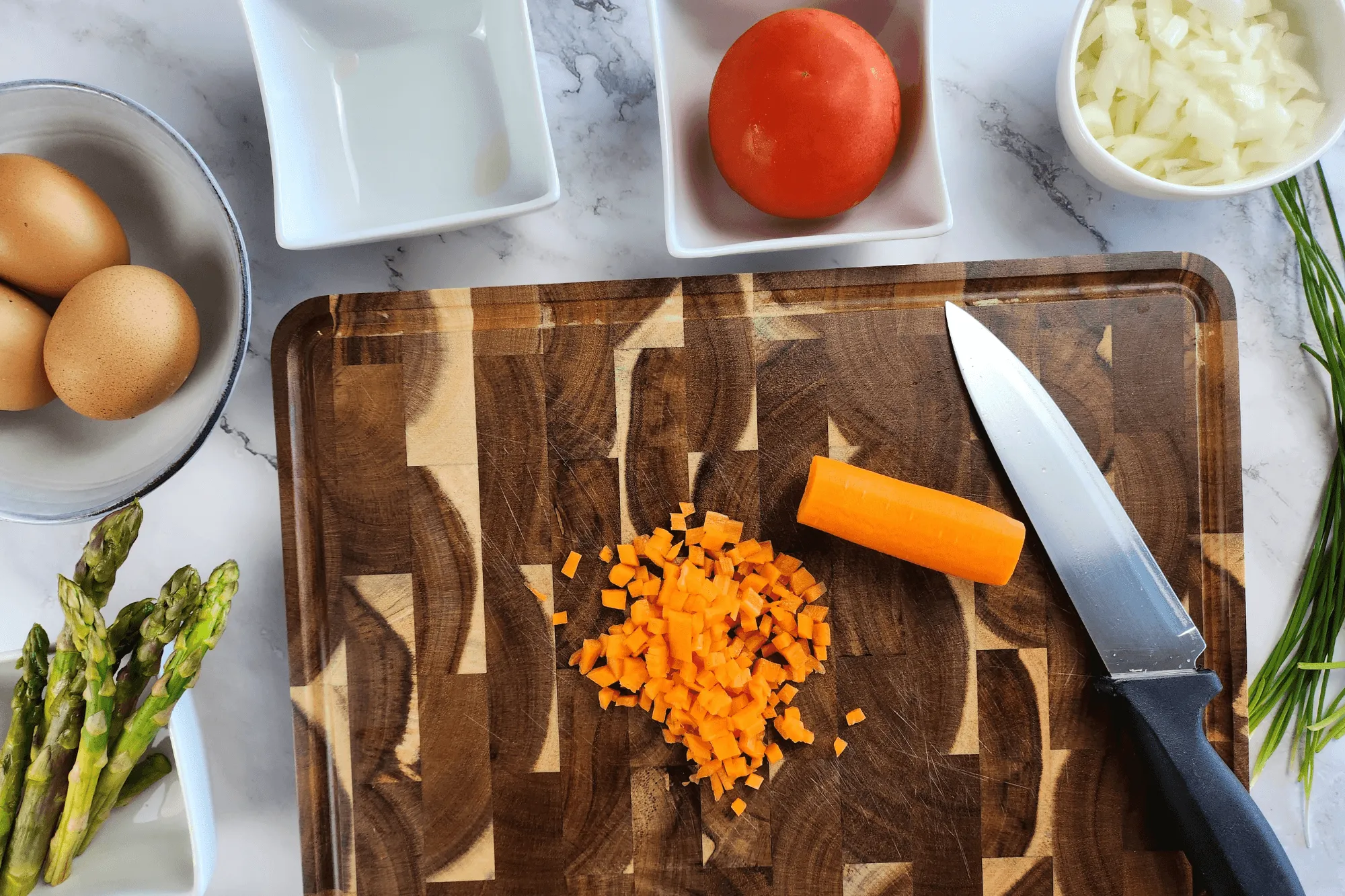 Chop the onion, carrot, asparagus, scallion, coriander and tomato into small pieces.