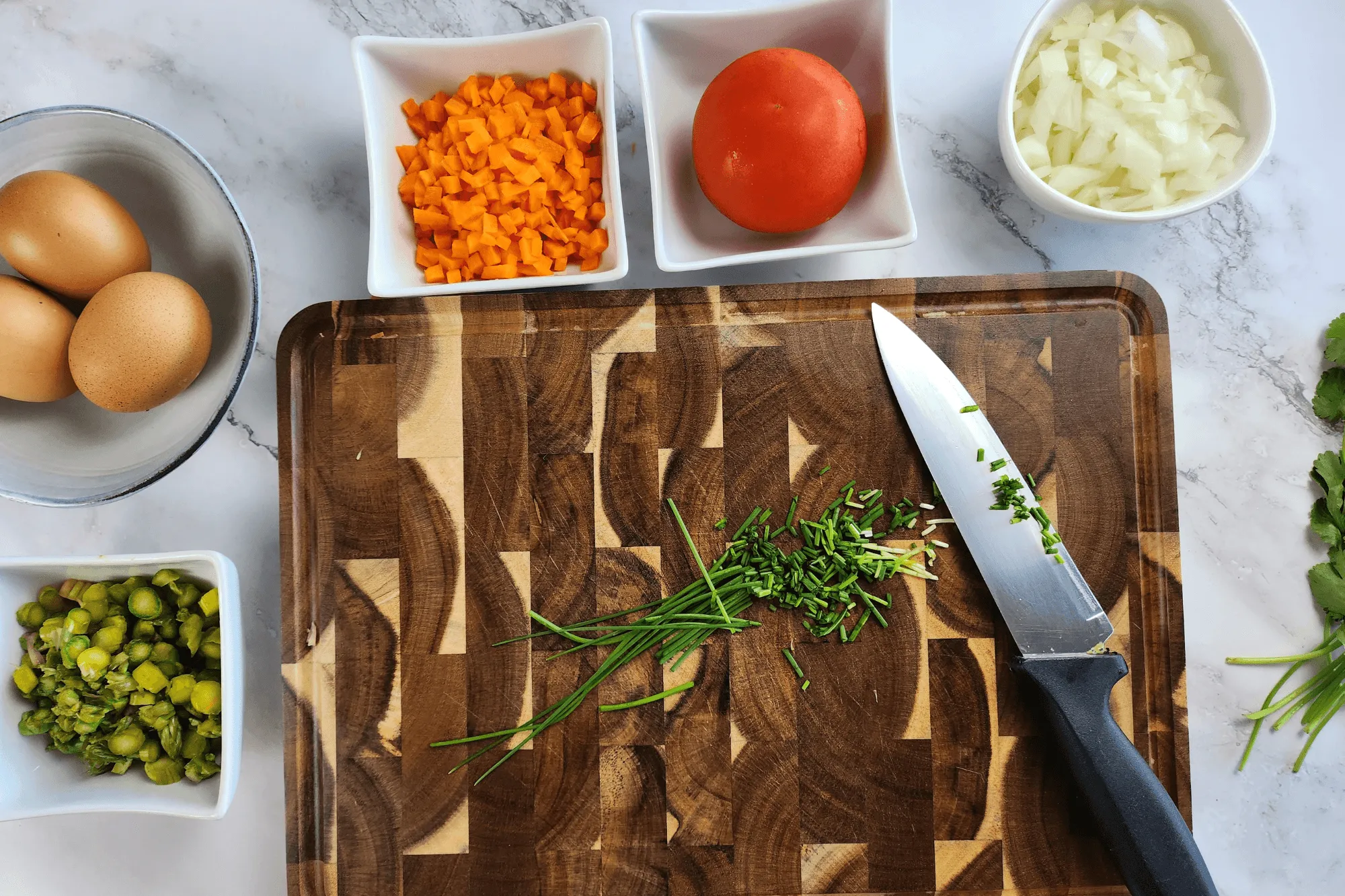 Chop the onion, carrot, asparagus, scallion, coriander and tomato into small pieces.