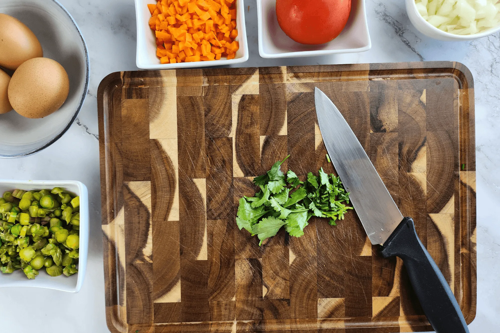 Chop the onion, carrot, asparagus, scallion, coriander and tomato into small pieces.