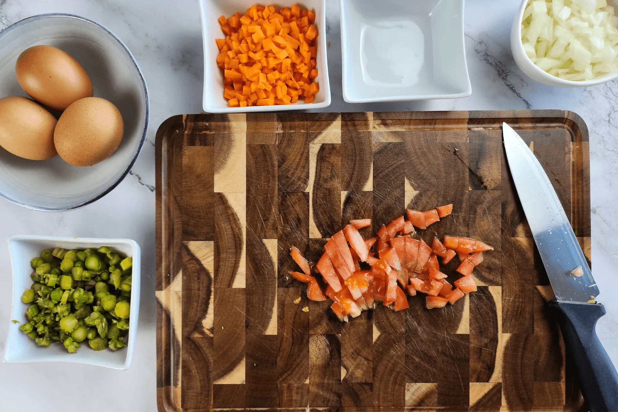 Chop the onion, carrot, asparagus, scallion, coriander and tomato into small pieces.