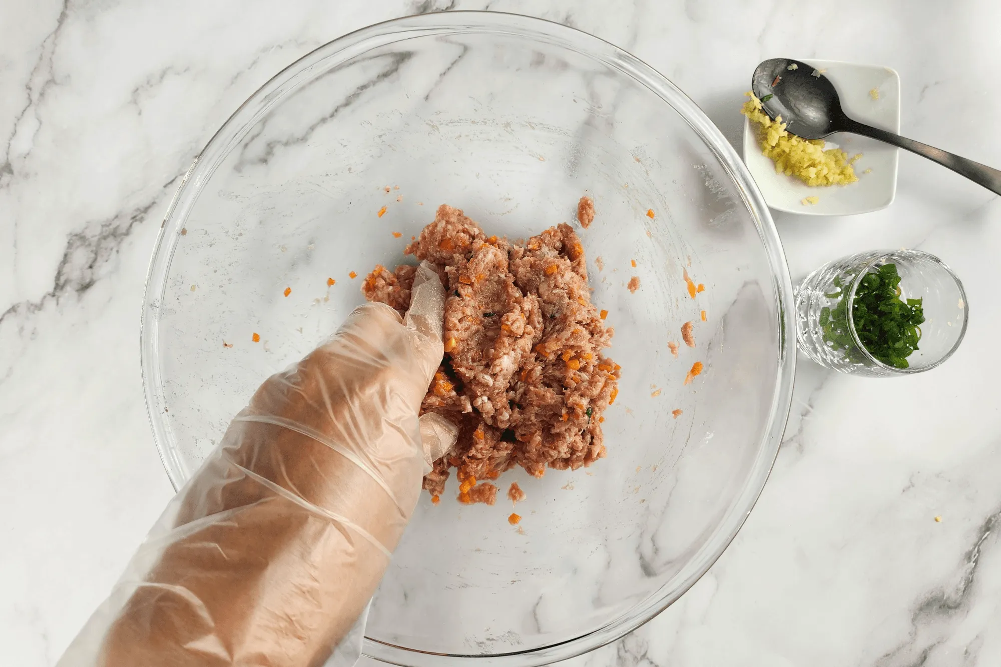 Combine the minced pork with carrot, ginger, and sliced green onion. Season with cornstarch, a pinch of salt, pepper, light soy sauce and  sesame oil.