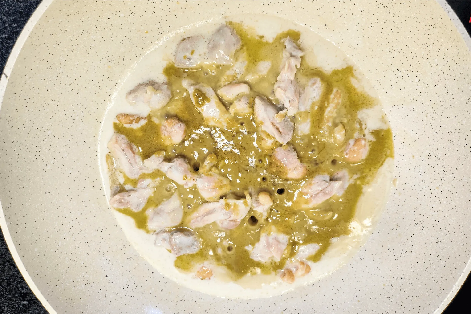 In a second pan, heat a portion of the coconut milk with the sliced chicken breast and cook until it's no longer pink.