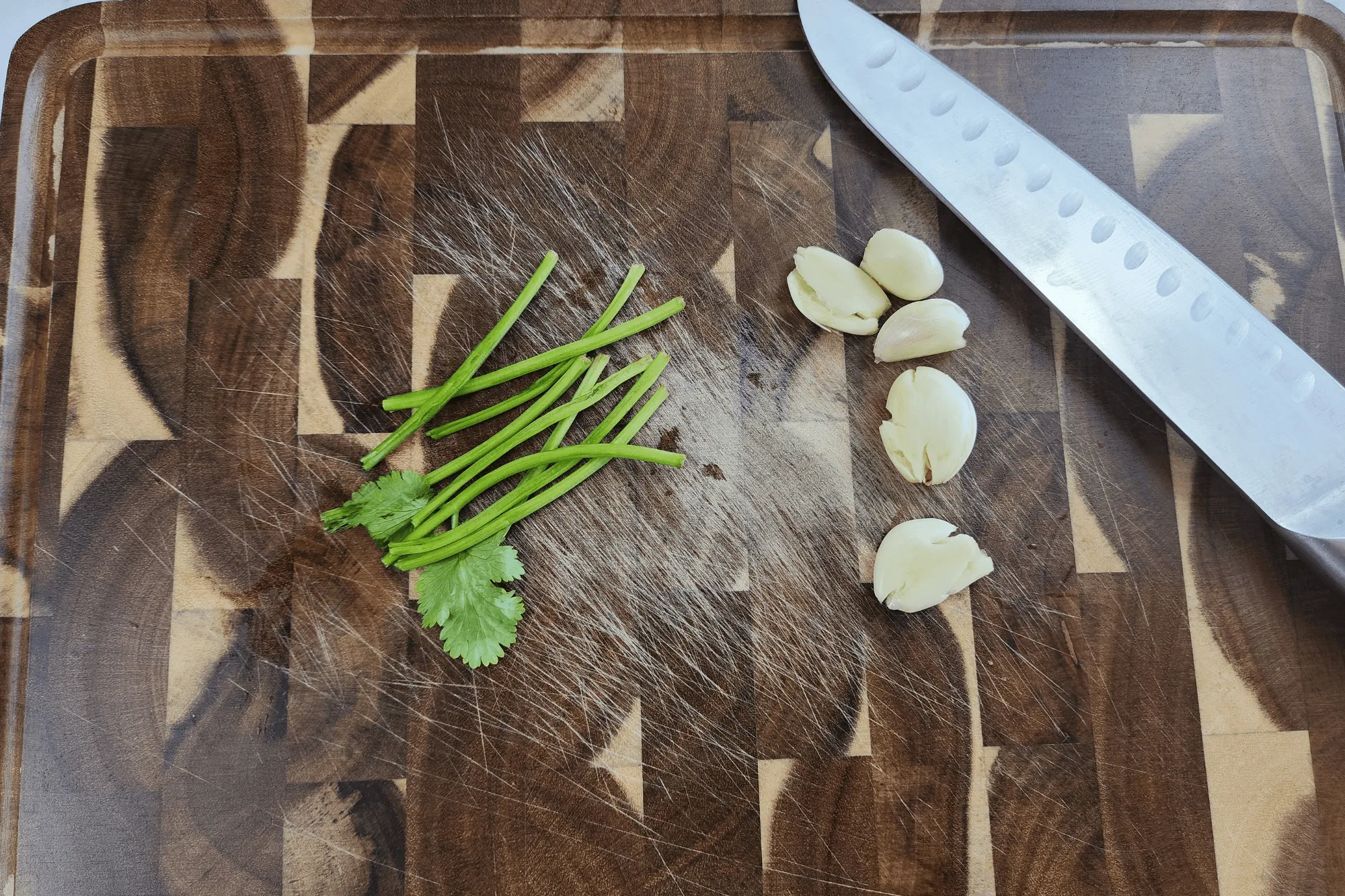 Crunch the garlic and coriander root/stem to release the aroma.