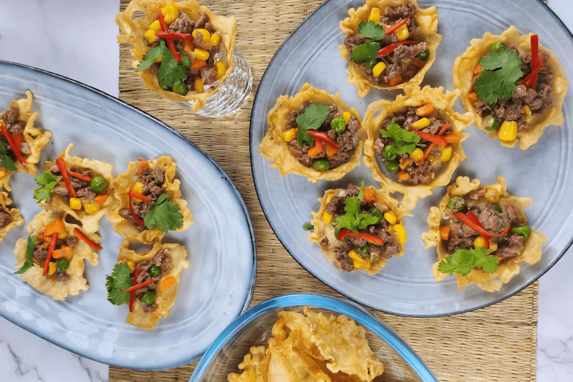 Garnish each tartlet with a coriander leaf and slivers of red chili.