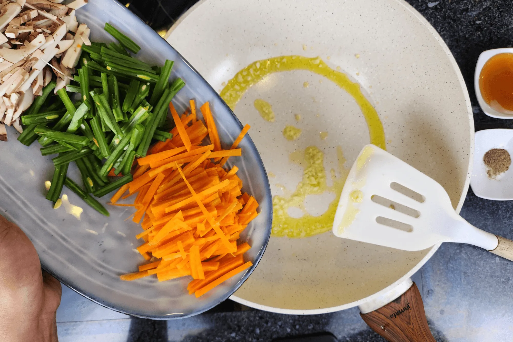 Heat a pan over medium heat, add oil, and once hot, sauté the galic until it fragants, then add the carrot, snow peas, and shiitake mushrooms until well combined.