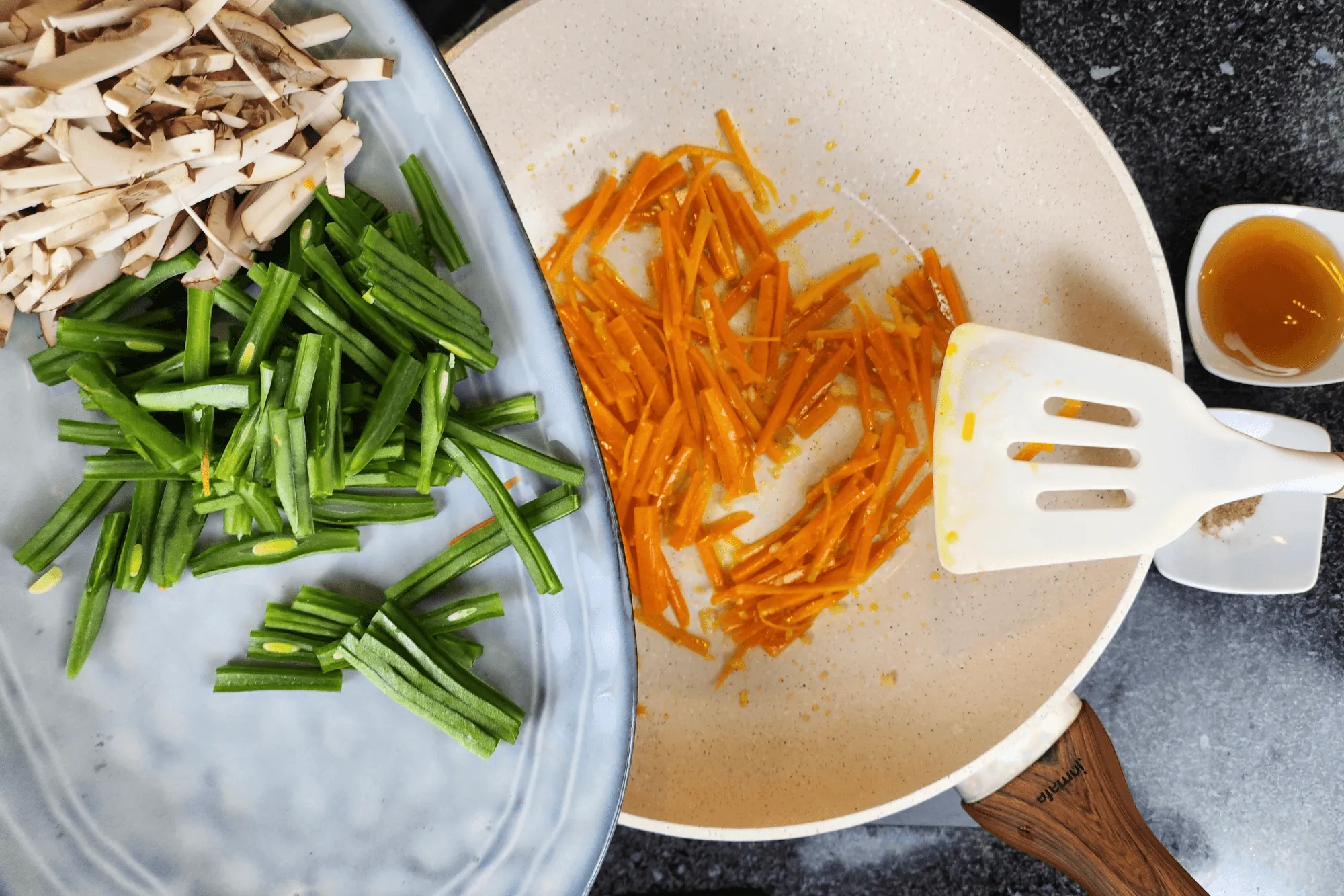 Heat a pan over medium heat, add oil, and once hot, sauté the galic until it fragants, then add the carrot, snow peas, and shiitake mushrooms until well combined.