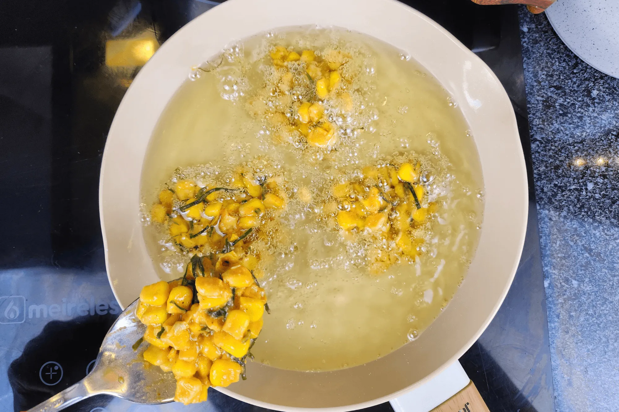 Heat oil in a frying pan over medium heat. Once the oil is hot, scoop small portions of the corn mixture into the pan and fry until golden and crispy.