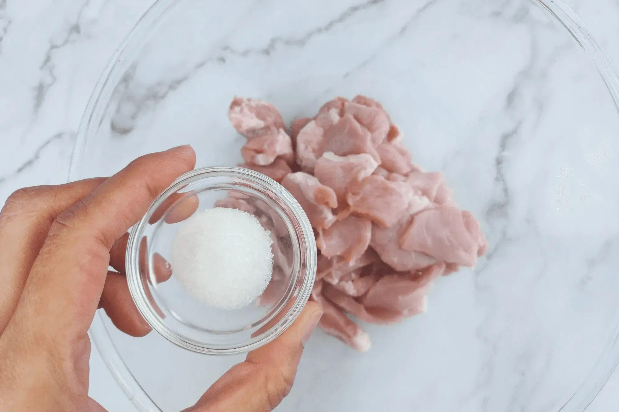 In a bowl, add sliced pork mix with grated ginger, mirin, and sugar.