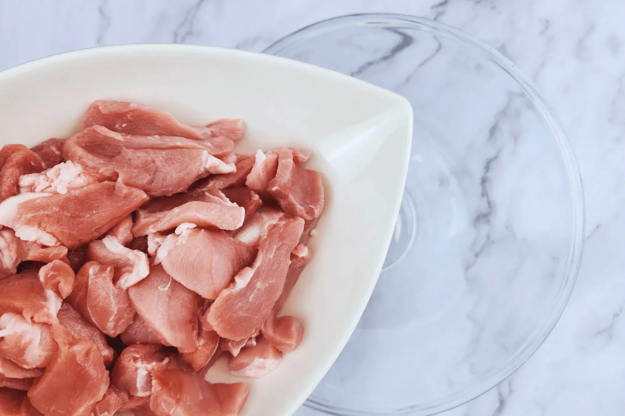 In a bowl, add sliced pork.