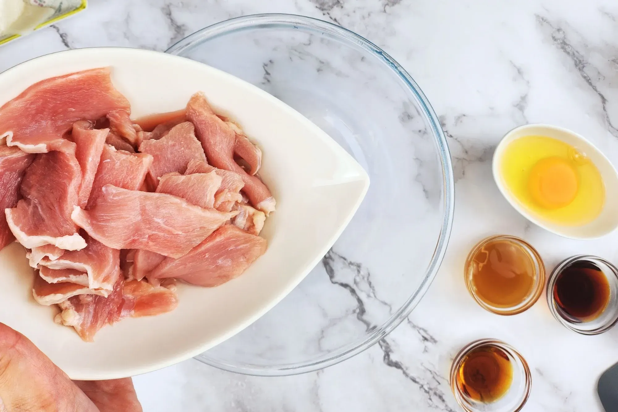 In the mixing bowl, add sliced pork 