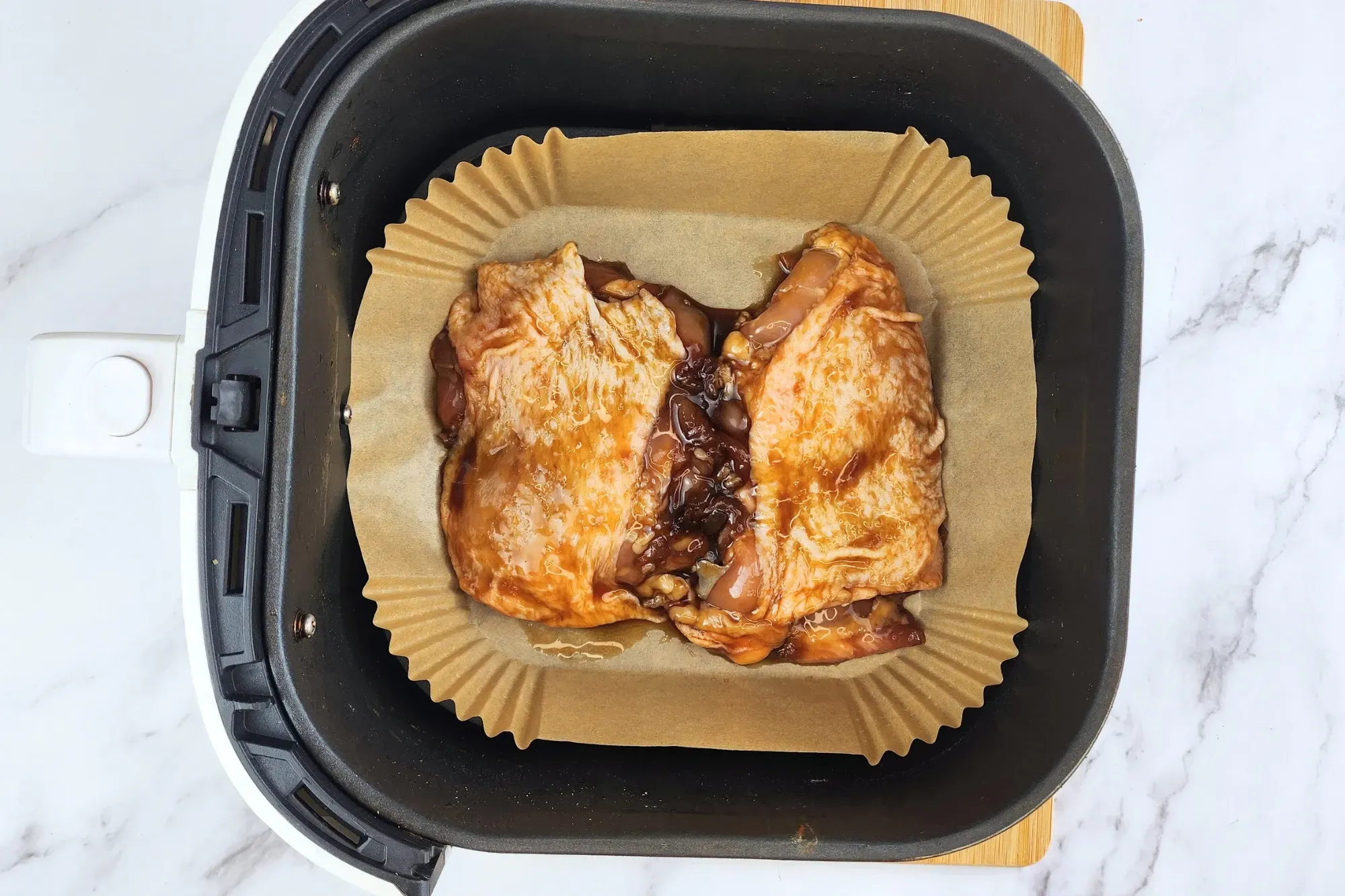 Place the marinated chicken thighs in the air fryer basket