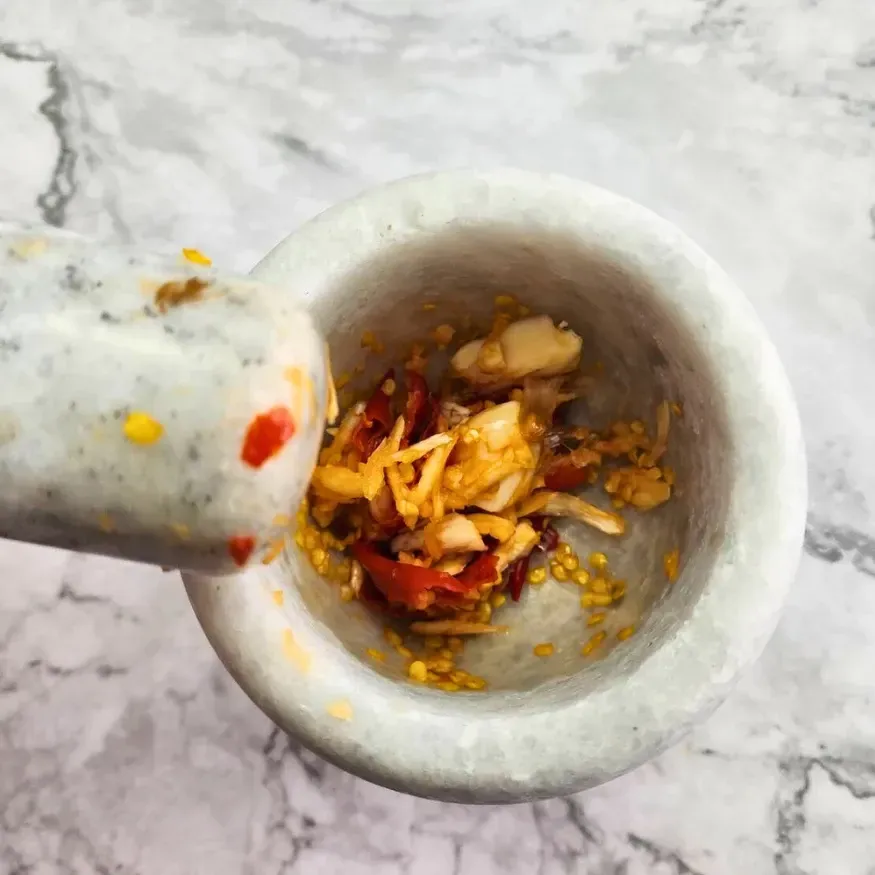 Crushed garlic and chilli in a pestle and mortar