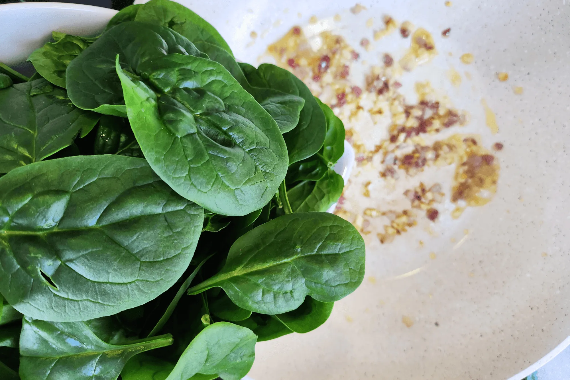 Once the garlic and shallots are fragrant, add the spinach and stir-fry. Season with salt and pepper. When the spinach is cooked, let the filling cool before wrapping.