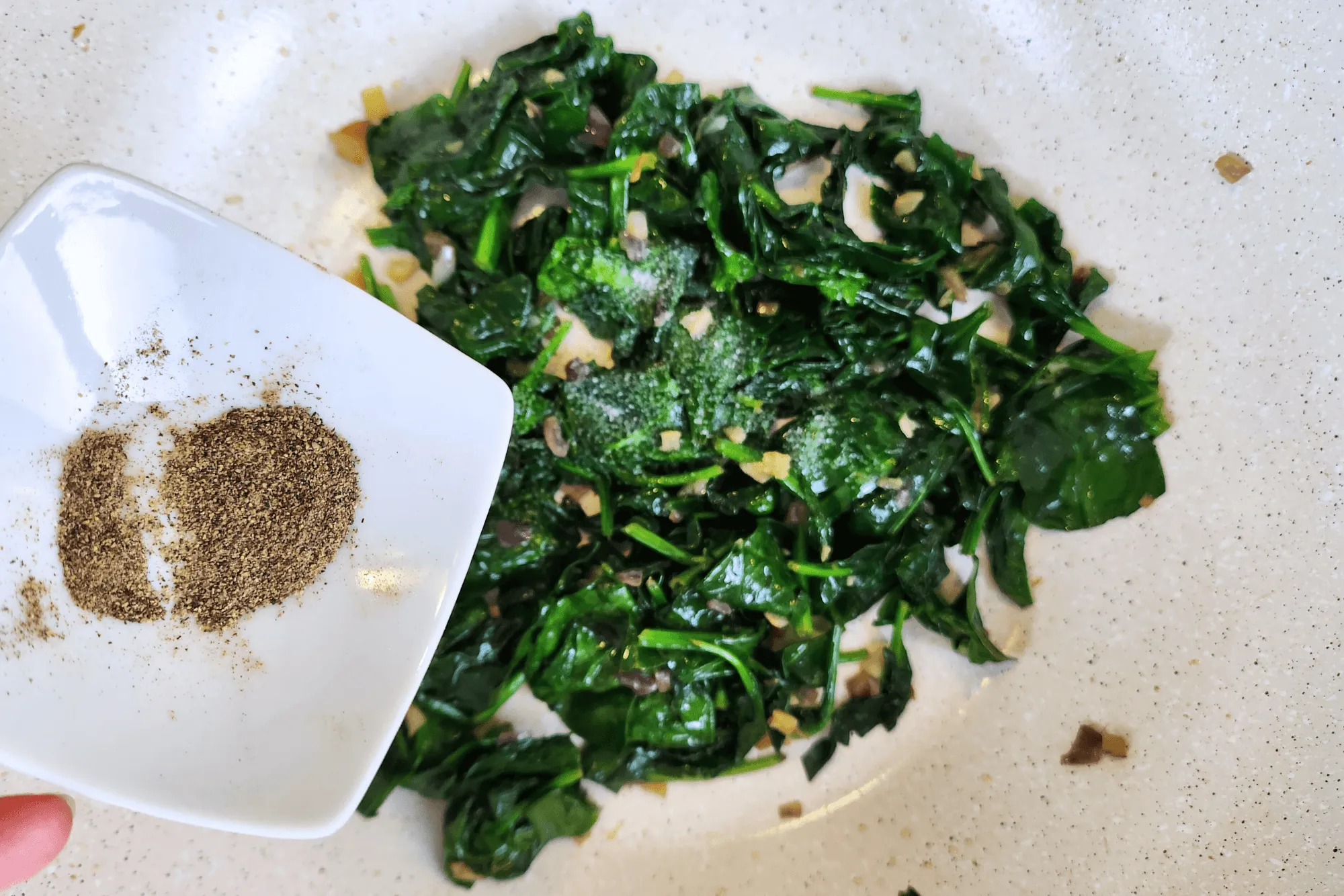 Once the garlic and shallots are fragrant, add the spinach and stir-fry. Season with salt and pepper. When the spinach is cooked, let the filling cool before wrapping.