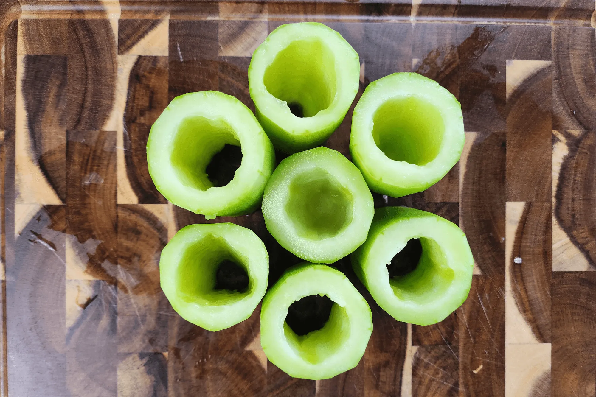 Peel the cucumbers, cut them into sections, and scoop out the seeds.