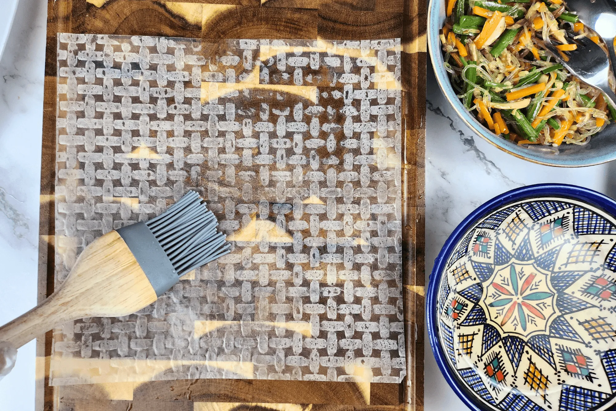 Place a sheet of rice paper on a flat surface and brush both sides with the vinegar solution until it softens.