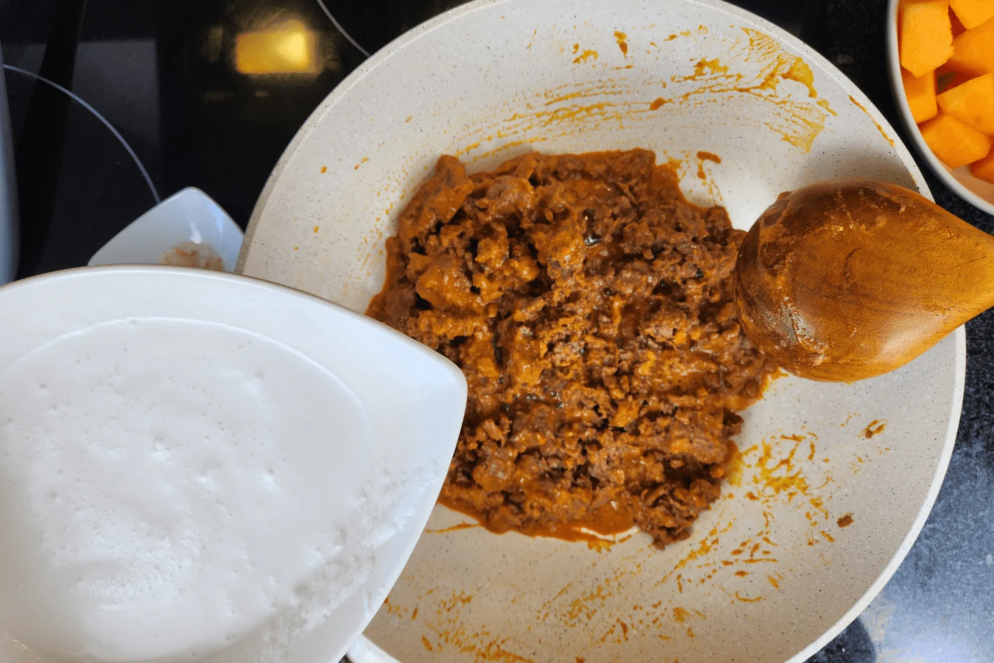 Pour in the remaining coconut milk. Once it begins to simmer, add the pumpkin pieces.