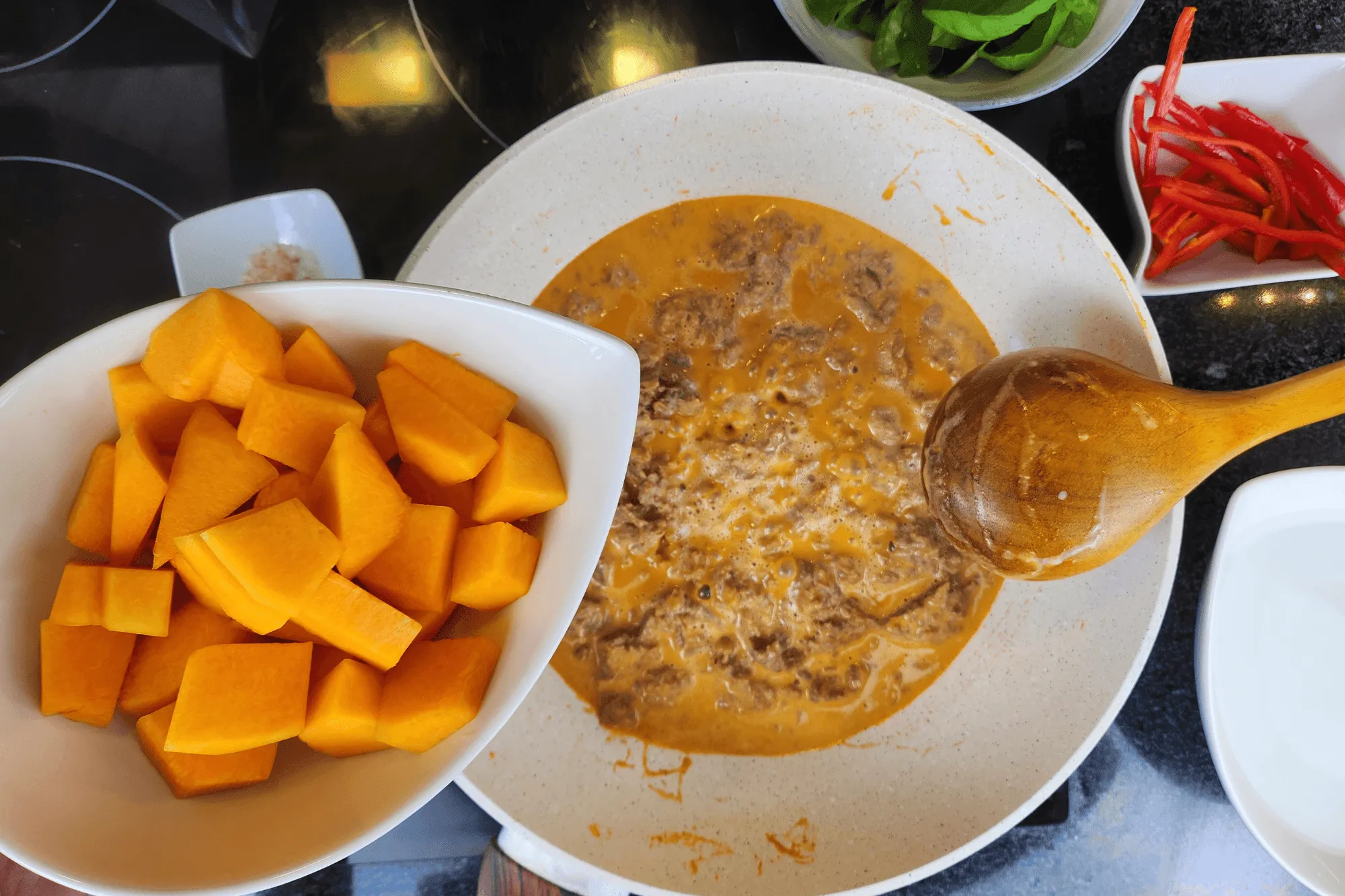 Pour in the remaining coconut milk. Once it begins to simmer, add the pumpkin pieces.