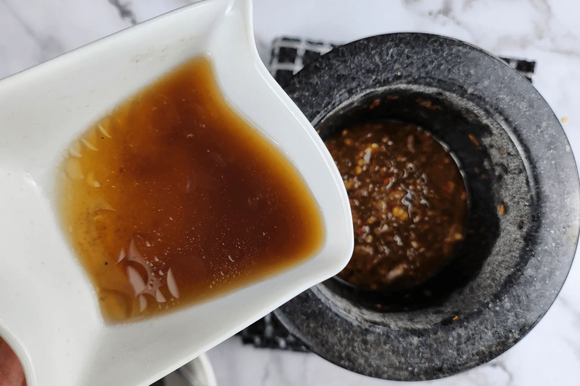 Season with coconut sugar, fish sauce, lime juice, and 2 tablespoons of the chicken broth from the cooking pot.