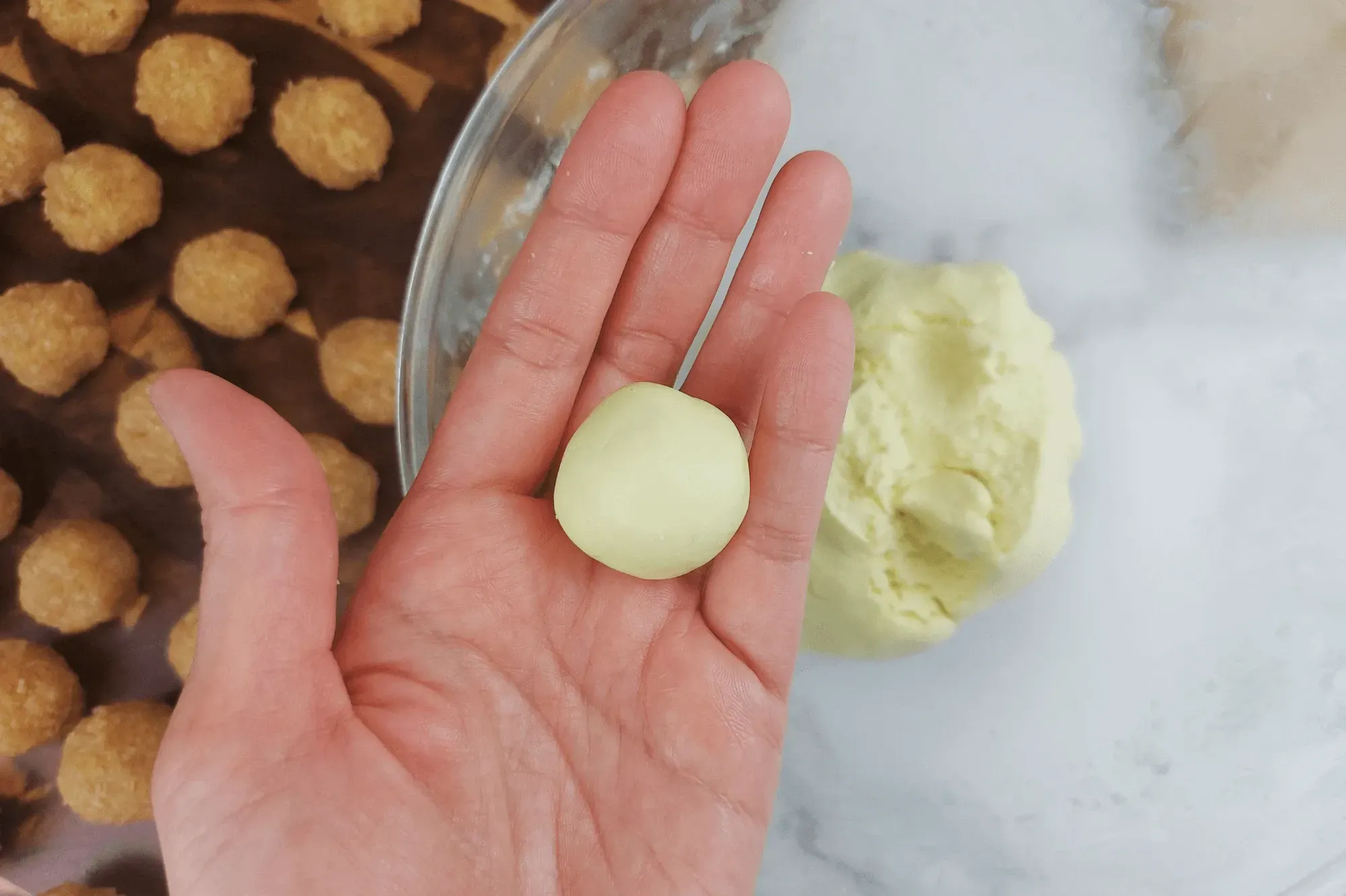 Shape the dough into small balls, slightly larger than the filling, so it can fully cover the filling.