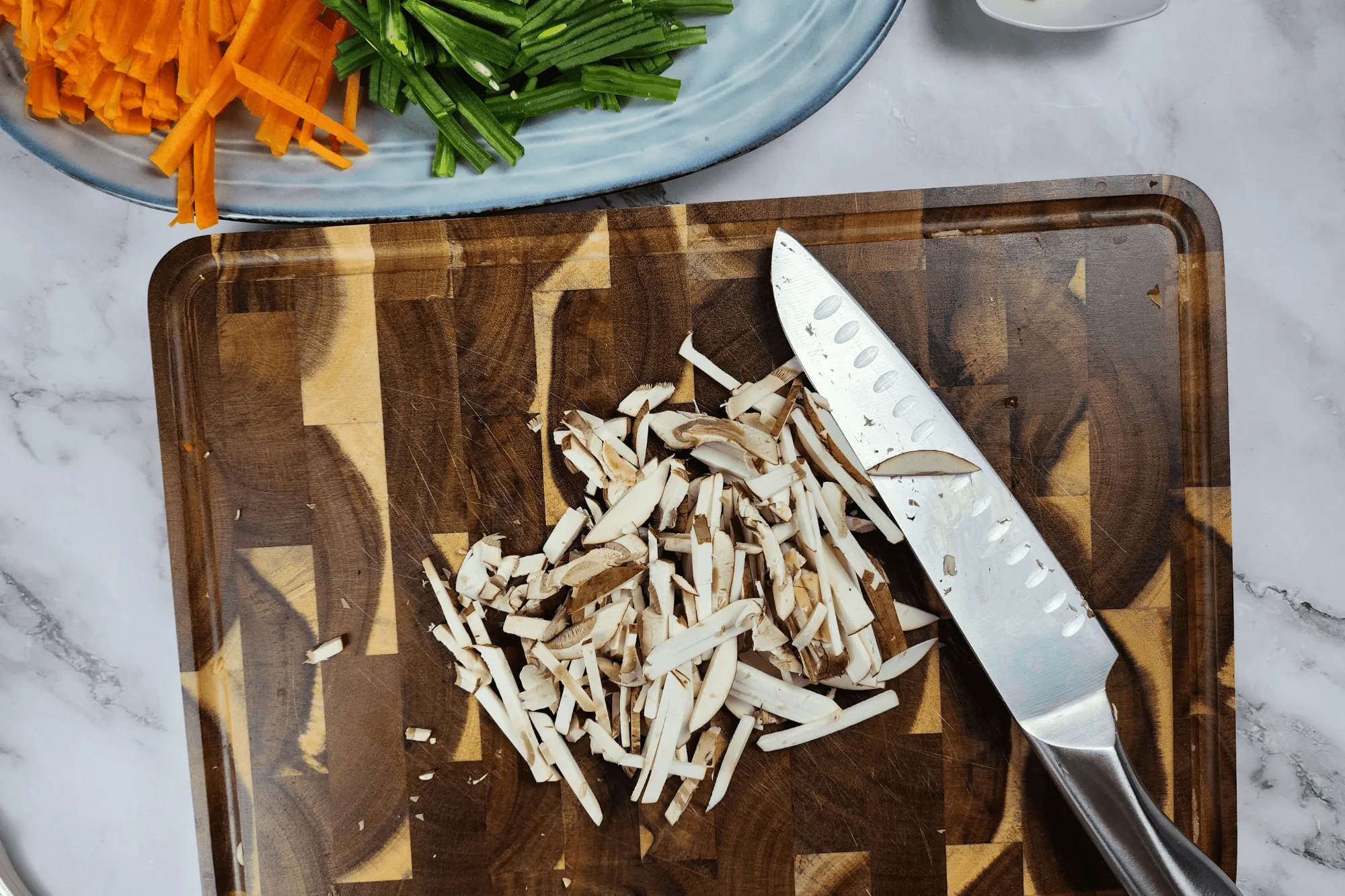 Slice the carrot, beans, and mushrooms into thin strips.