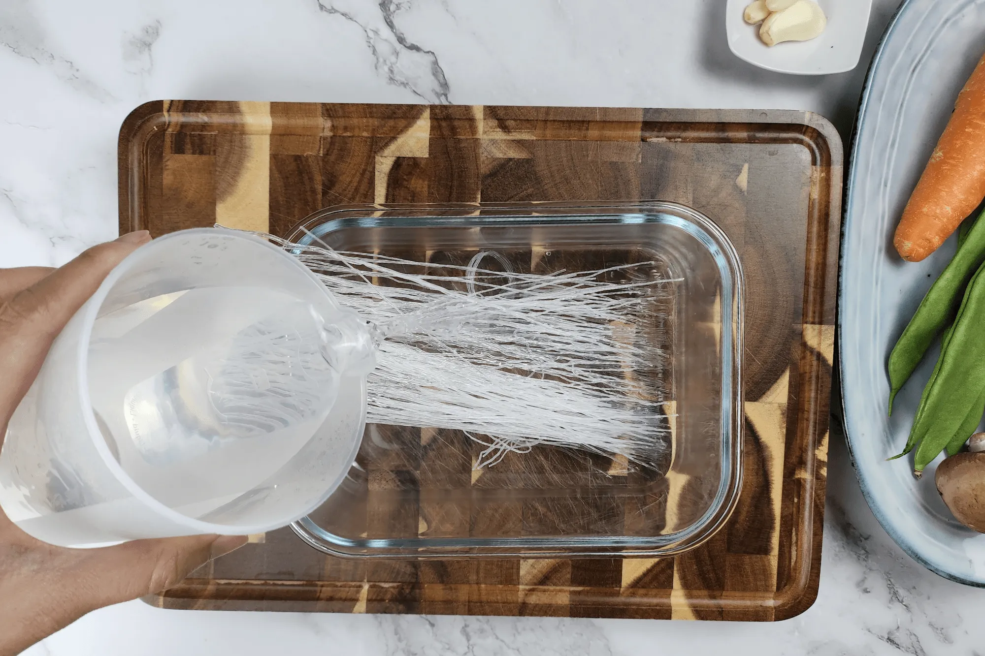 Soak the glass noodles in hot water for 5 minutes until softened. Drain and cut the noodles into shorter lengths.