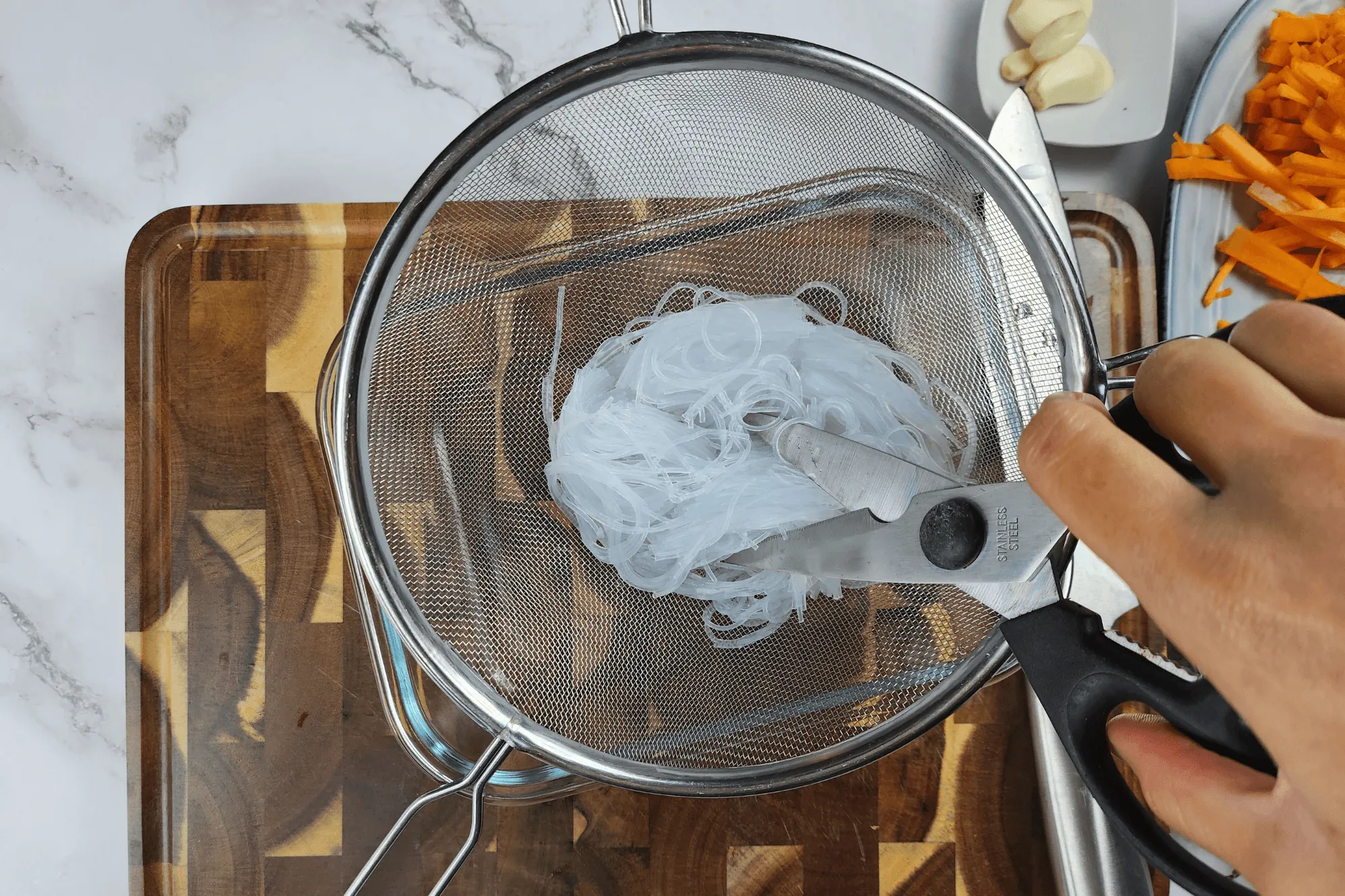 Soak the glass noodles in hot water for 5 minutes until softened. Drain and cut the noodles into shorter lengths.