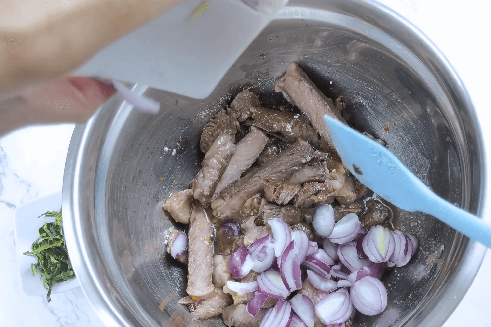 Add sliced shallots, chopped coriander, mint leaves, and sliced kaffir lime leaves. Plate and serve immediately.