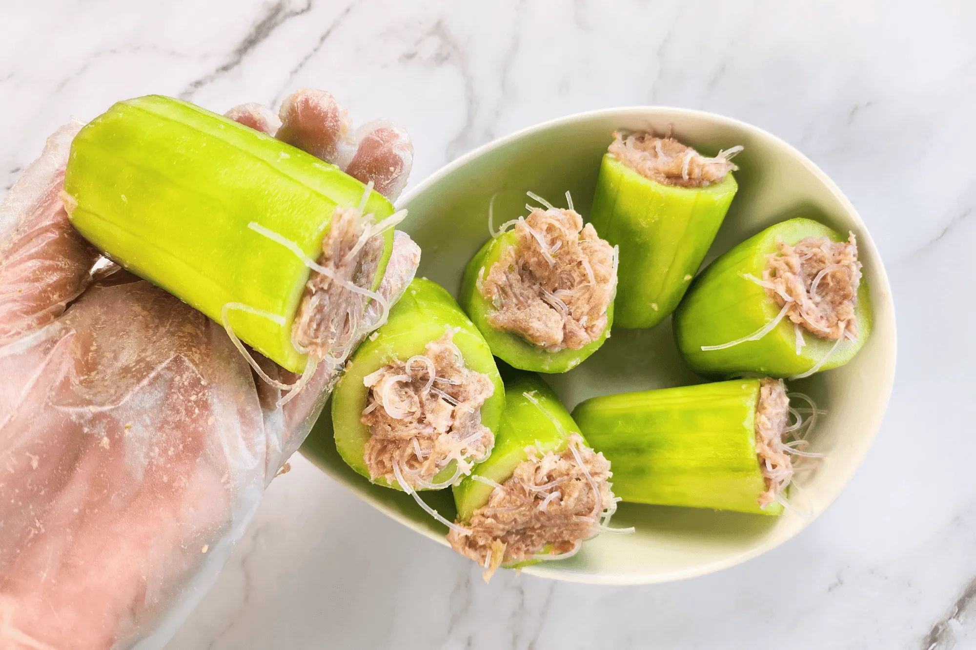 Stuff the seasoned pork mixture into the cucumber sections.