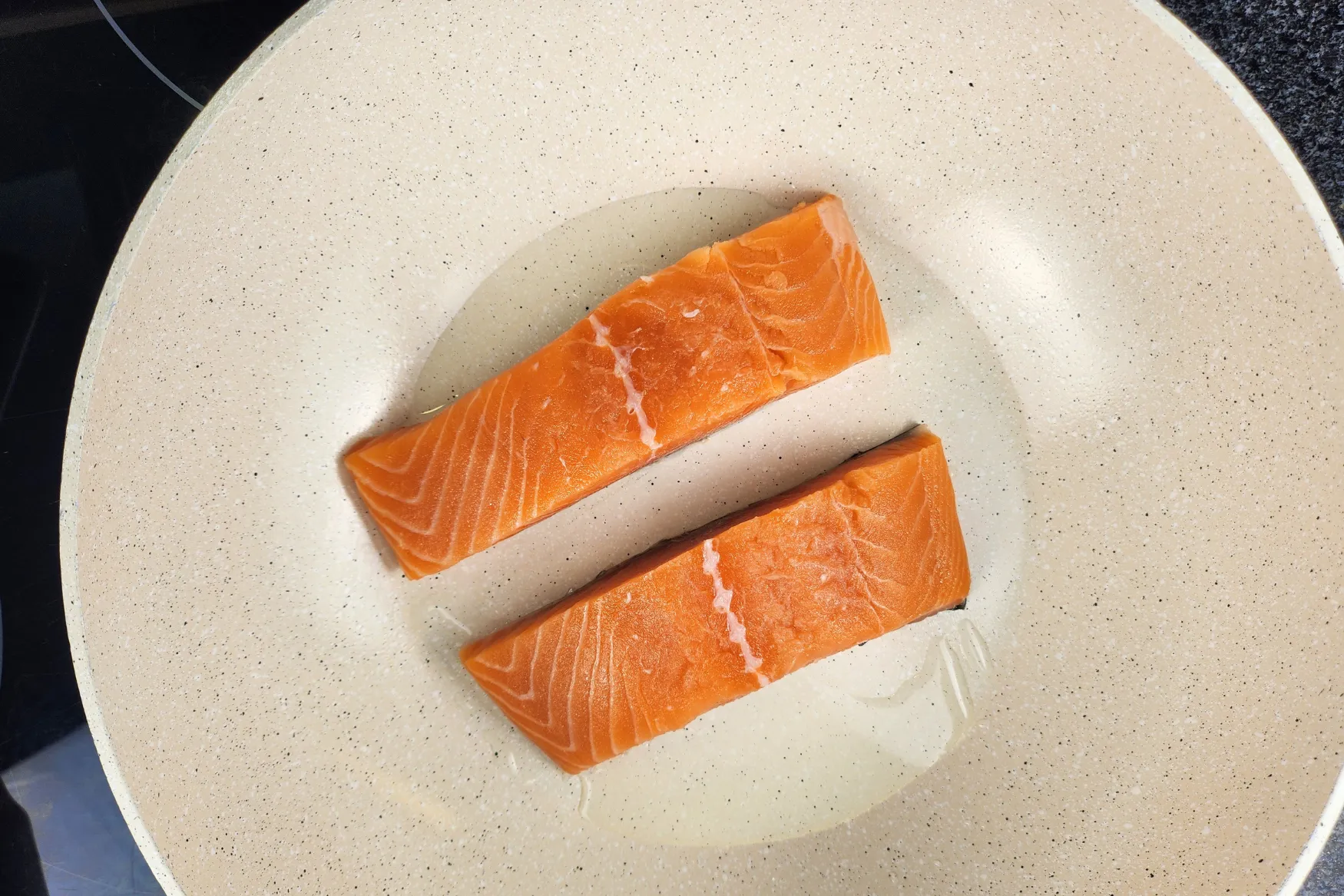 Uncooked salmon fillets in a wok