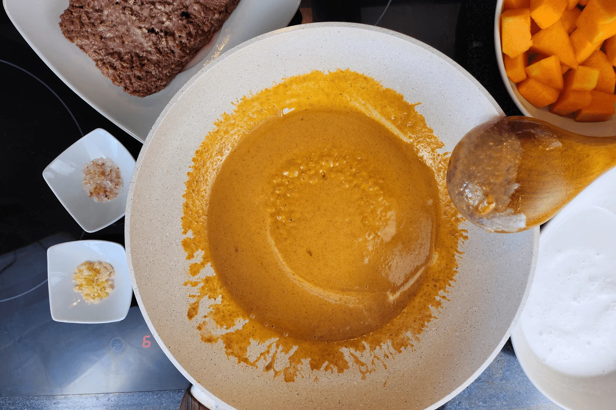 When the coconut milk begins to boil and the oil separates, add the red curry paste and stir until well combined.