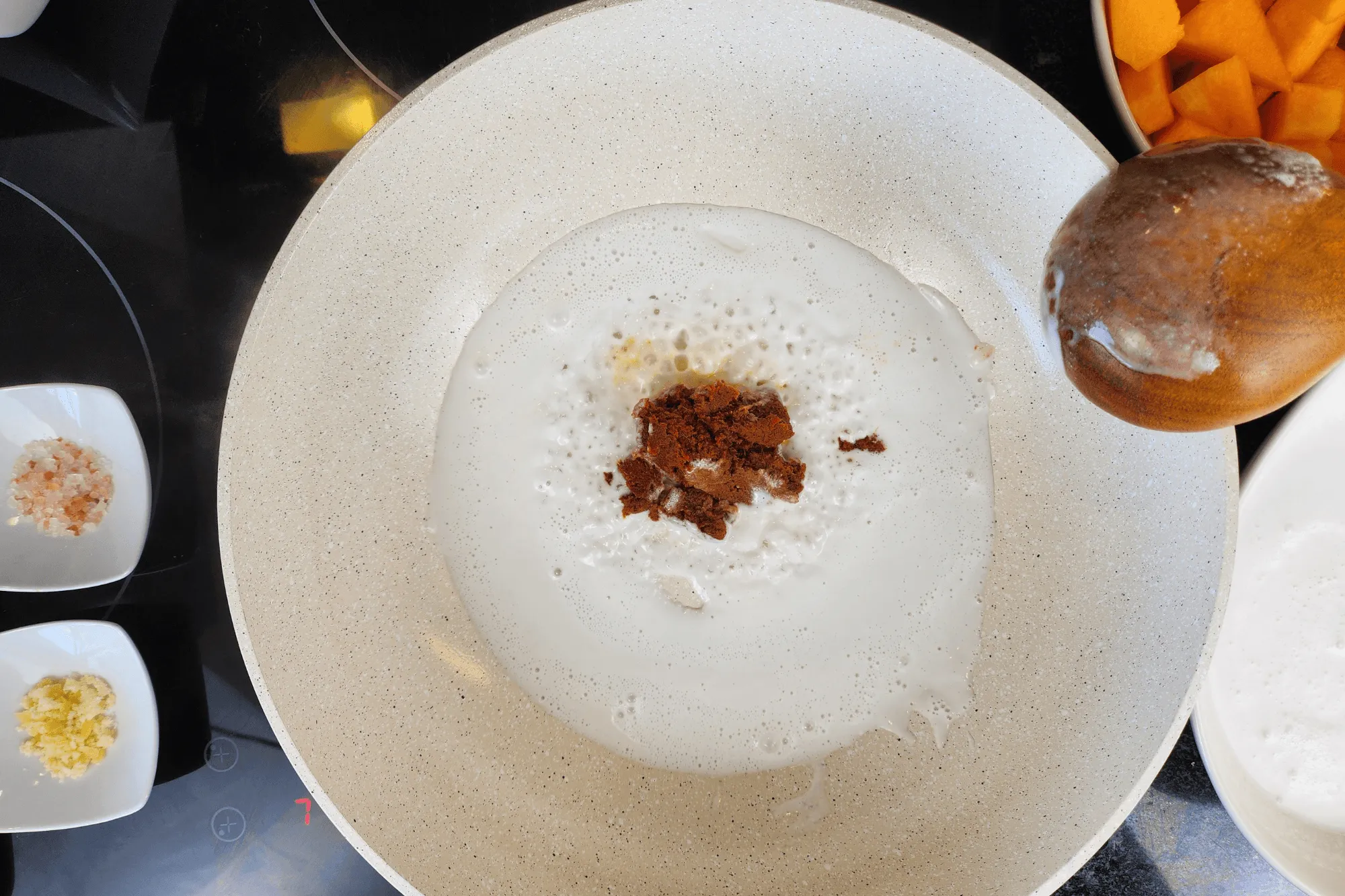 When the coconut milk begins to boil and the oil separates, add the red curry paste and stir until well combined.