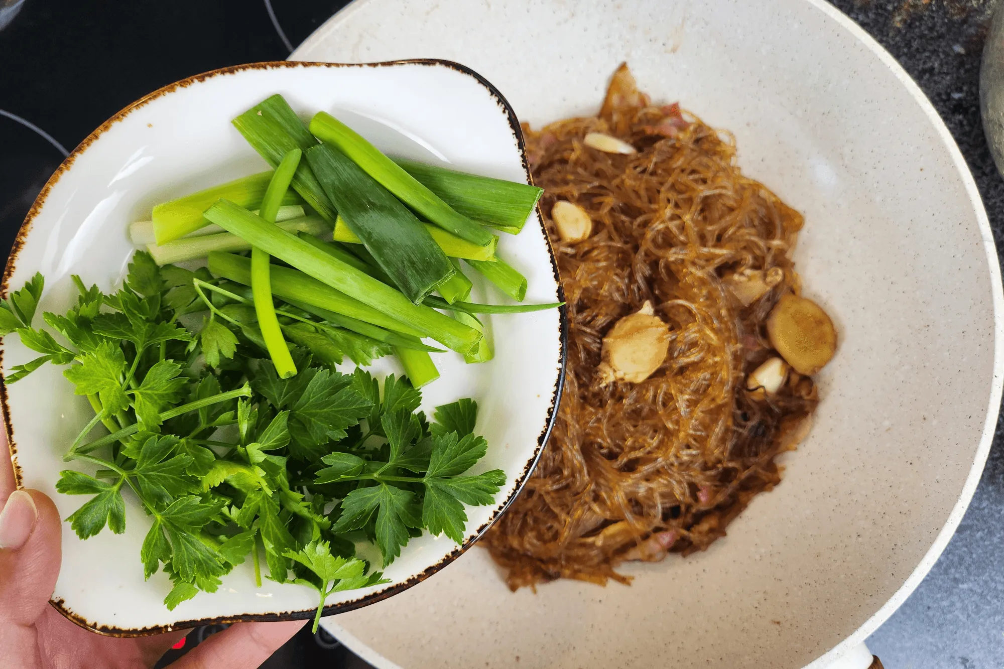 When the noodles start drying out, add green onions and Chinese celery.